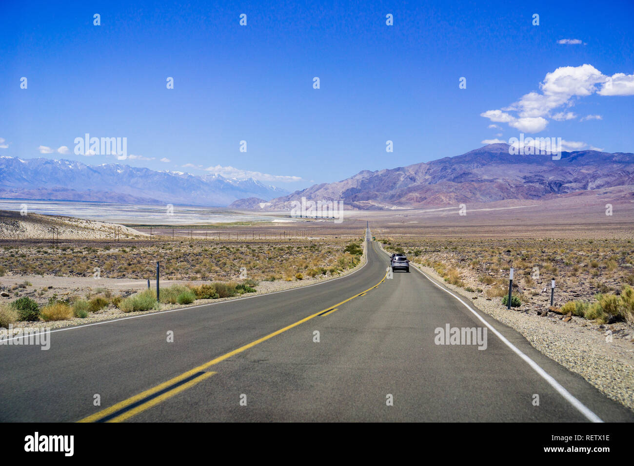 La guida su autostrada attraverso la contea di Inyo; catena montuosa della Sierra con cime innevate sulla sinistra; California Foto Stock