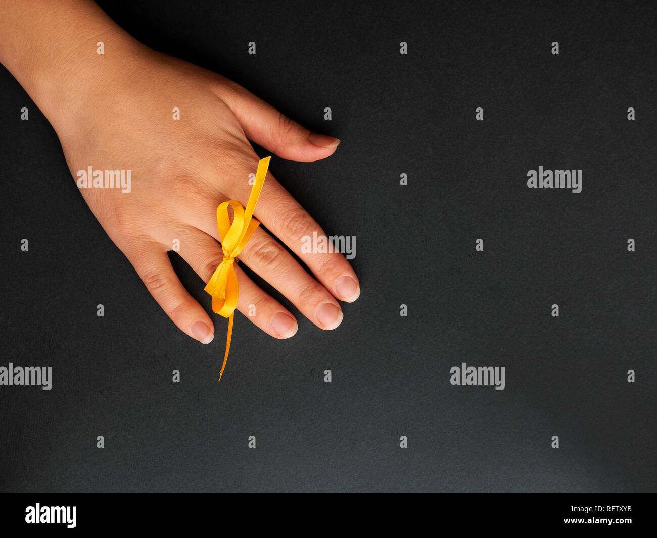 Le mani di un giovane nell'amore. Dita legate da un arco giallo Foto Stock