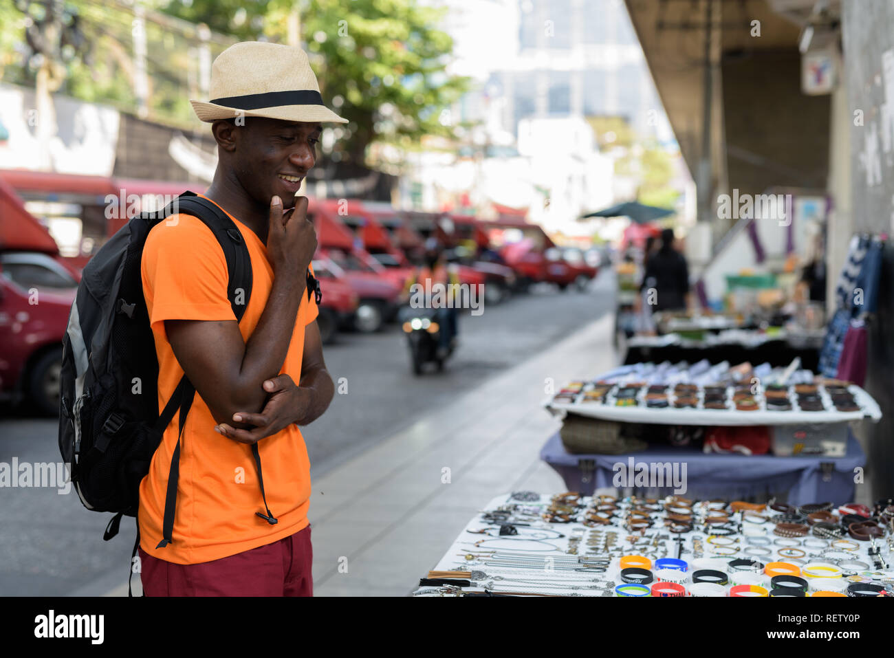 Giovani felici Africano nero tourist uomo sorridente e shopping all'aperto Foto Stock