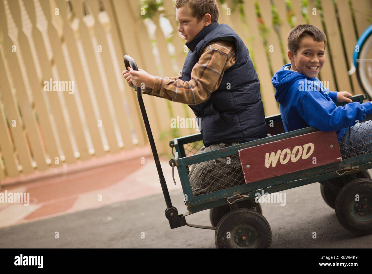 Due ragazzi seduti in un vecchio carro sul marciapiede. Foto Stock