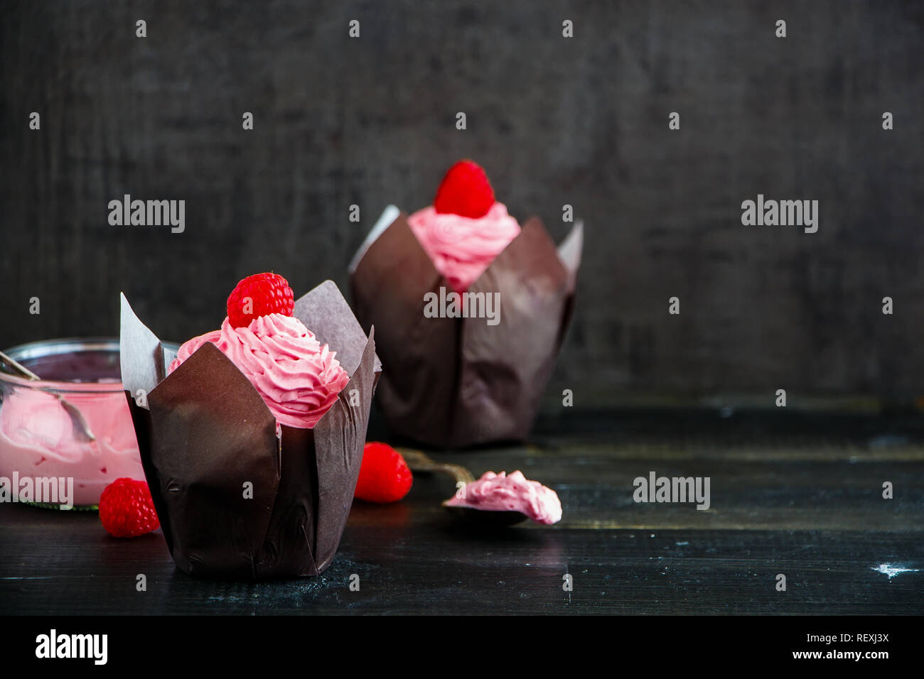 Deliziose tortine. Tortini di glassa decorata con un fresco e lampone e rosa di crema di formaggio Foto Stock