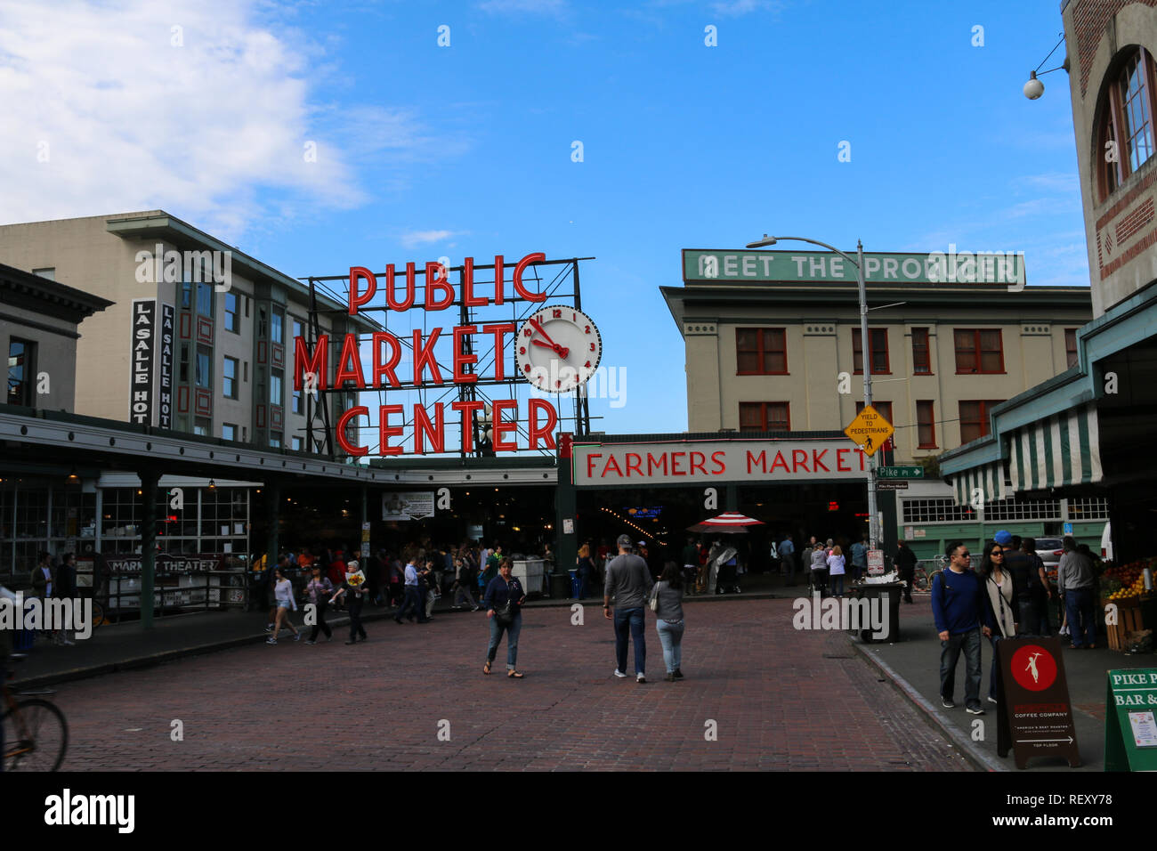 Segno iconico e ingresso al Mercato di Pike Place a Seattle, nello Stato di Washington in una giornata di sole con cielo blu e nuvole parziale, shoppers passando da Foto Stock