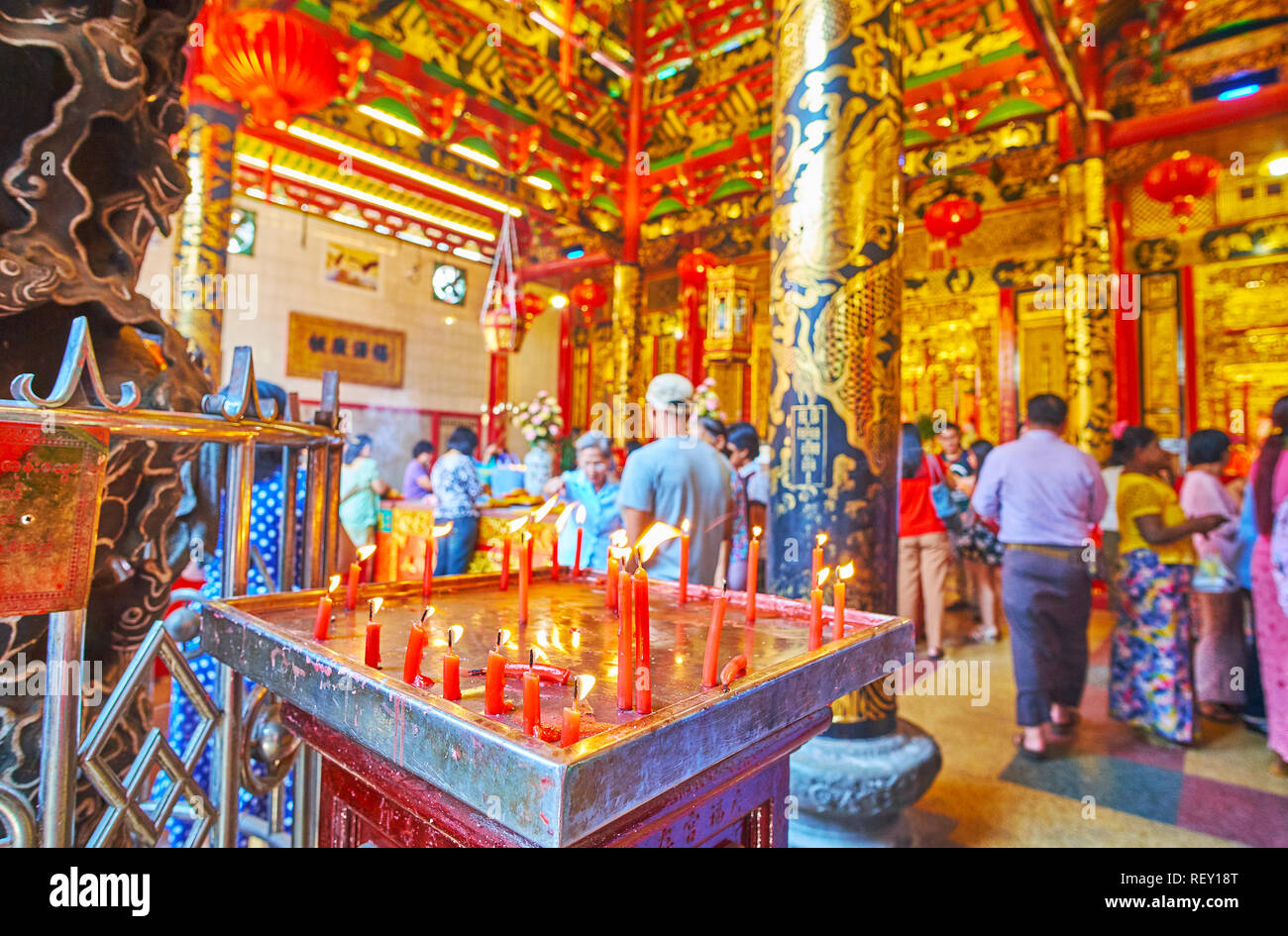 YANGON, MYANMAR - 17 febbraio 2018: la vista sulla affollata sala da preghiera di Hock Kheng Keong tempio del mare Dea Mazu dietro le candele accese, su FEB. Foto Stock