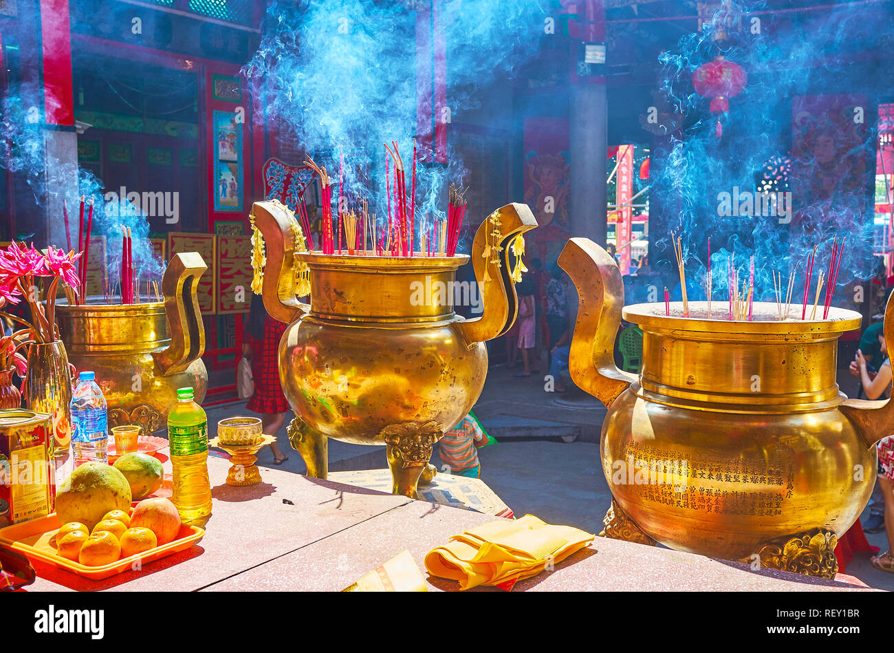 YANGON, MYANMAR - 17 febbraio 2018: le nuvole di fumo di fragrante intorno ai grandi vasi di rame con aroma bastoni nel cortile di Hock Kheng Keong Temp Foto Stock