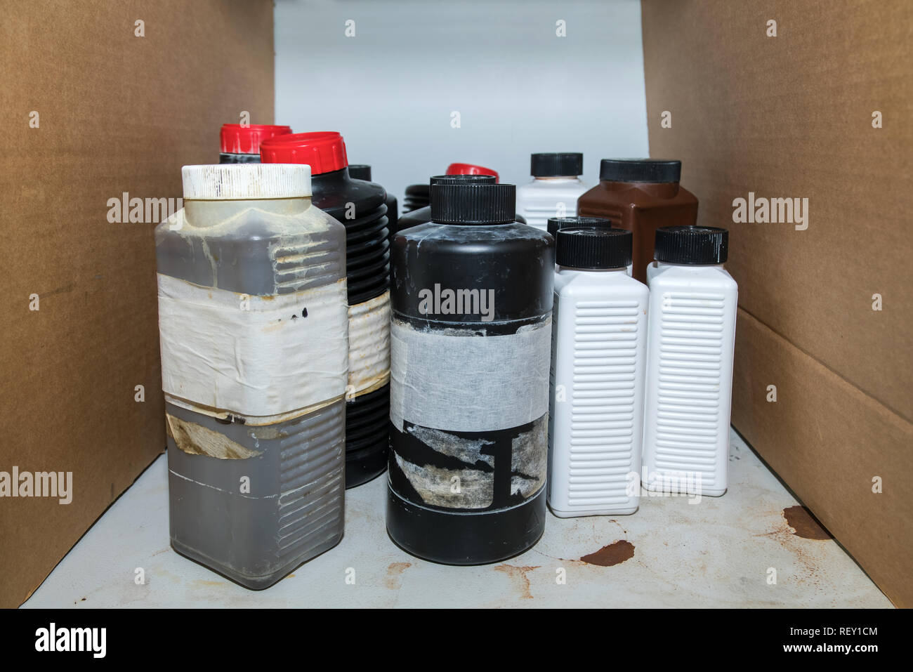 Infiammabile Le sostanze chimiche pericolose in bottiglia di plastica contenitori su di un ripiano in laboratorio Foto Stock