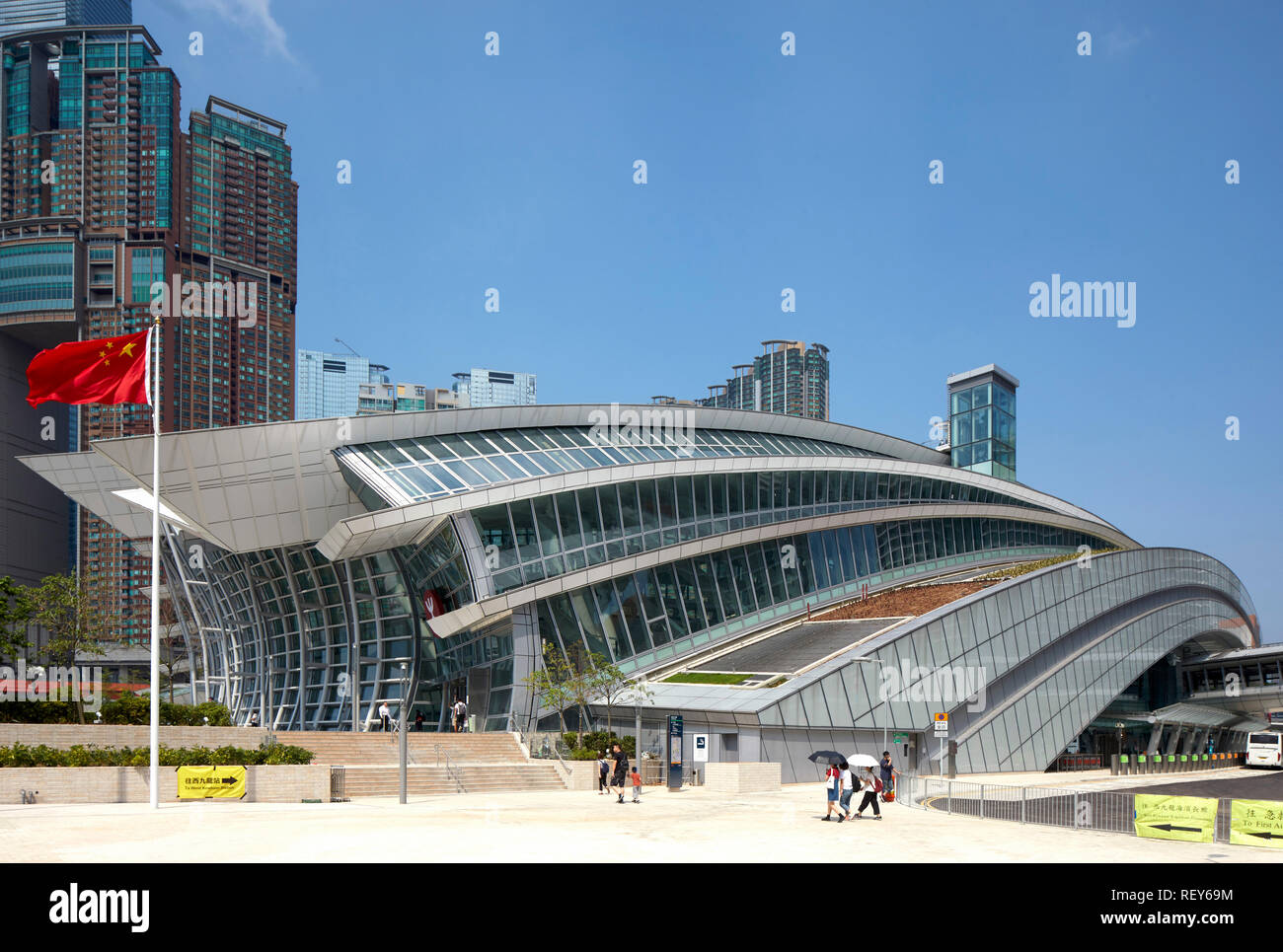 Vista dal lato approccio con bandiera cinese. A ovest della stazione di Kowloon, Hong Kong, Cina. Architetto: Andrew Bromberg Aedas, 2018. Foto Stock