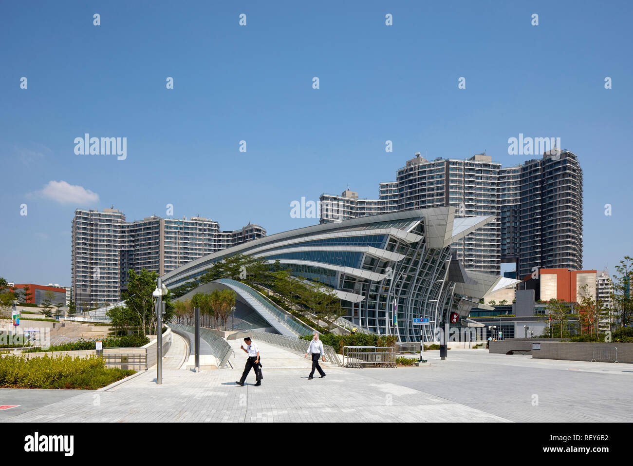 Vista globale con il passaggio di figure. A ovest della stazione di Kowloon, Hong Kong, Cina. Architetto: Andrew Bromberg Aedas, 2018. Foto Stock