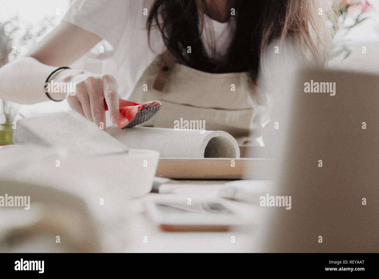 Donna fare ceramica. Vista dettagliata del processo di levigatura a piastra di argilla Foto Stock