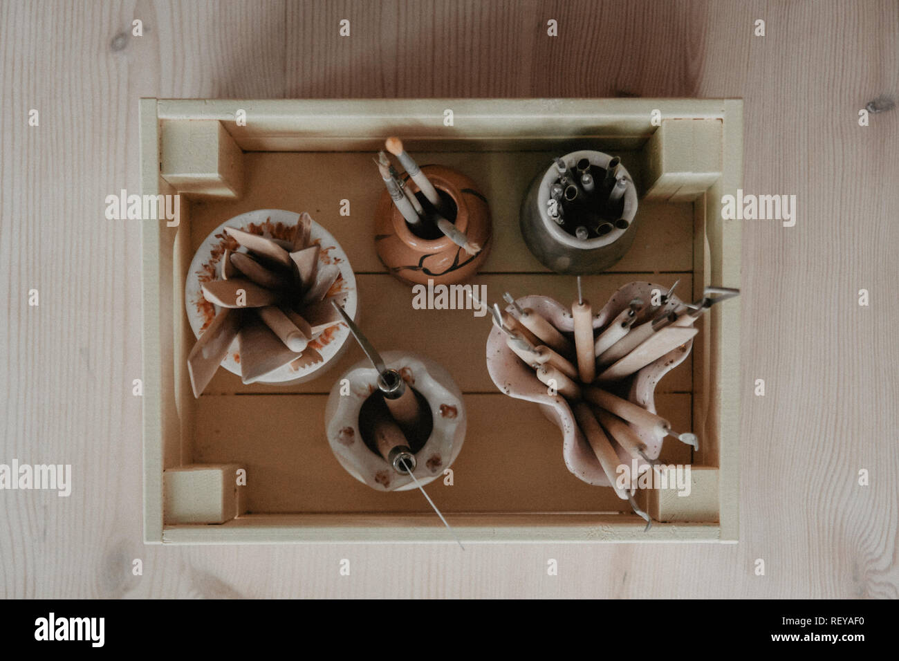 Set di sporco arte e artigianato scultura strumenti sul tavolo di legno nel laboratorio di ceramica Foto Stock