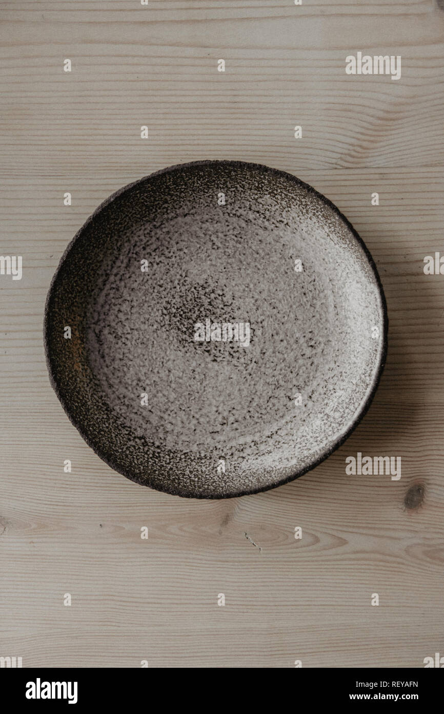 Decorativa piastra di argilla, su uno sfondo di legno con copia spazio. Foto Stock