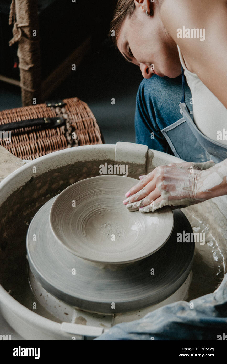 Creazione di un vaso o in un vaso di argilla bianca di close-up. Donna mani rendendo brocca di argilla. Foto Stock