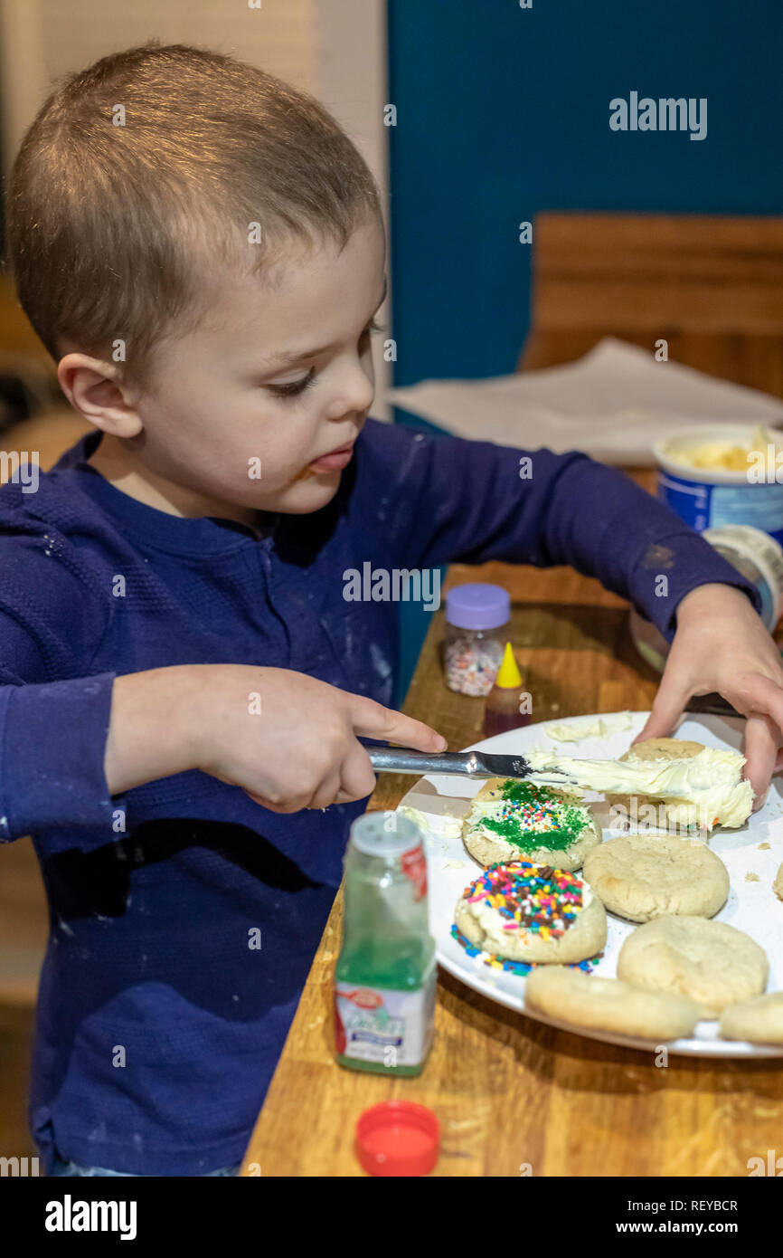 Denver, Colorado - quattro-anno-vecchio Adamo Hjermstad Jr. rende biscotti di Natale nella sua famiglia la cucina. Foto Stock