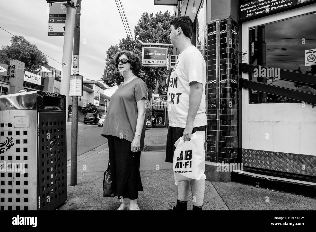 Due persone davanti a un semaforo per le strade di Melbourne, Australia Foto Stock