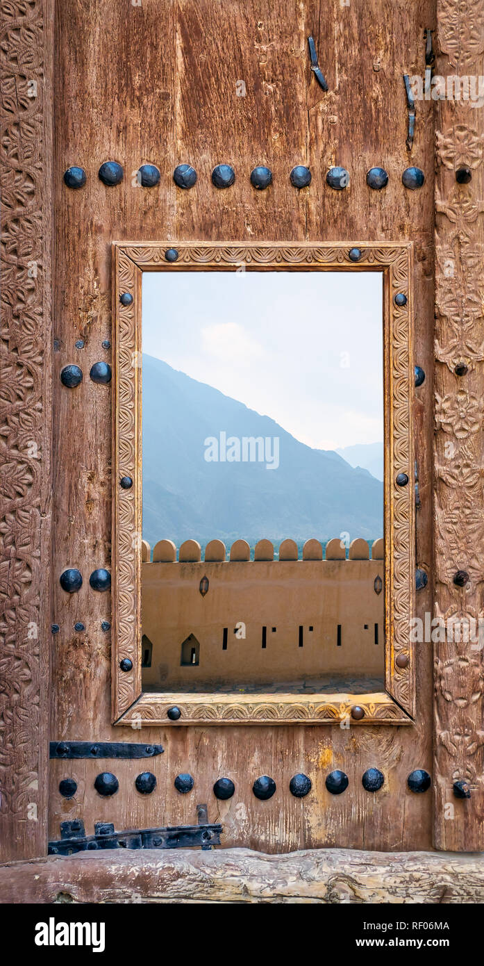 Antico cancello in legno con intarsi e una piccola trappola porta alla terrazza di un fort Foto Stock