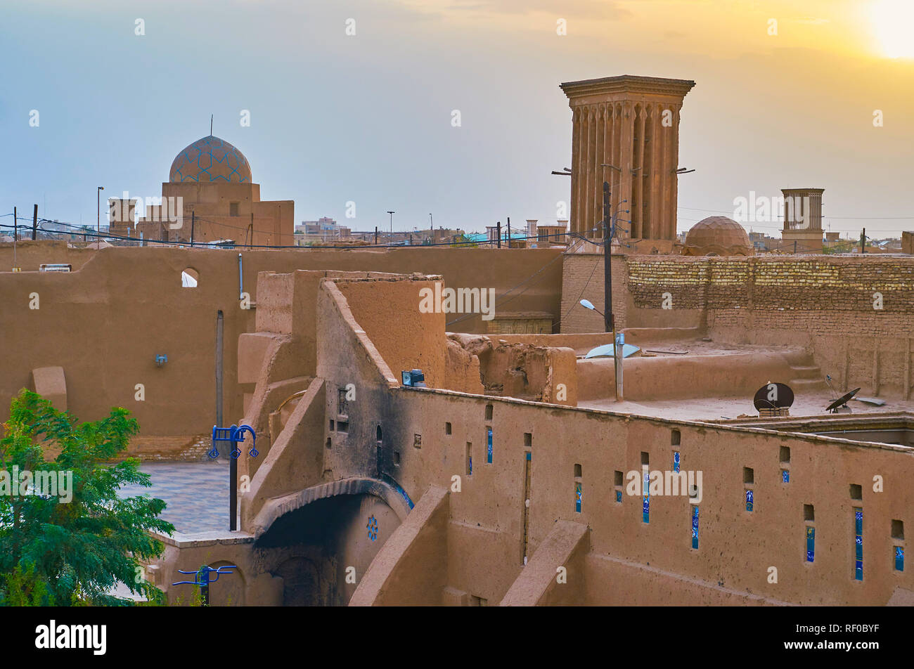 Il tramonto skyline del quartiere Fahadan con una vista su alte pareti di adobe, badgirs (torri del vento) e cupola stellare di Madraseh-e Kamalieh, Yazd, Iran. Foto Stock
