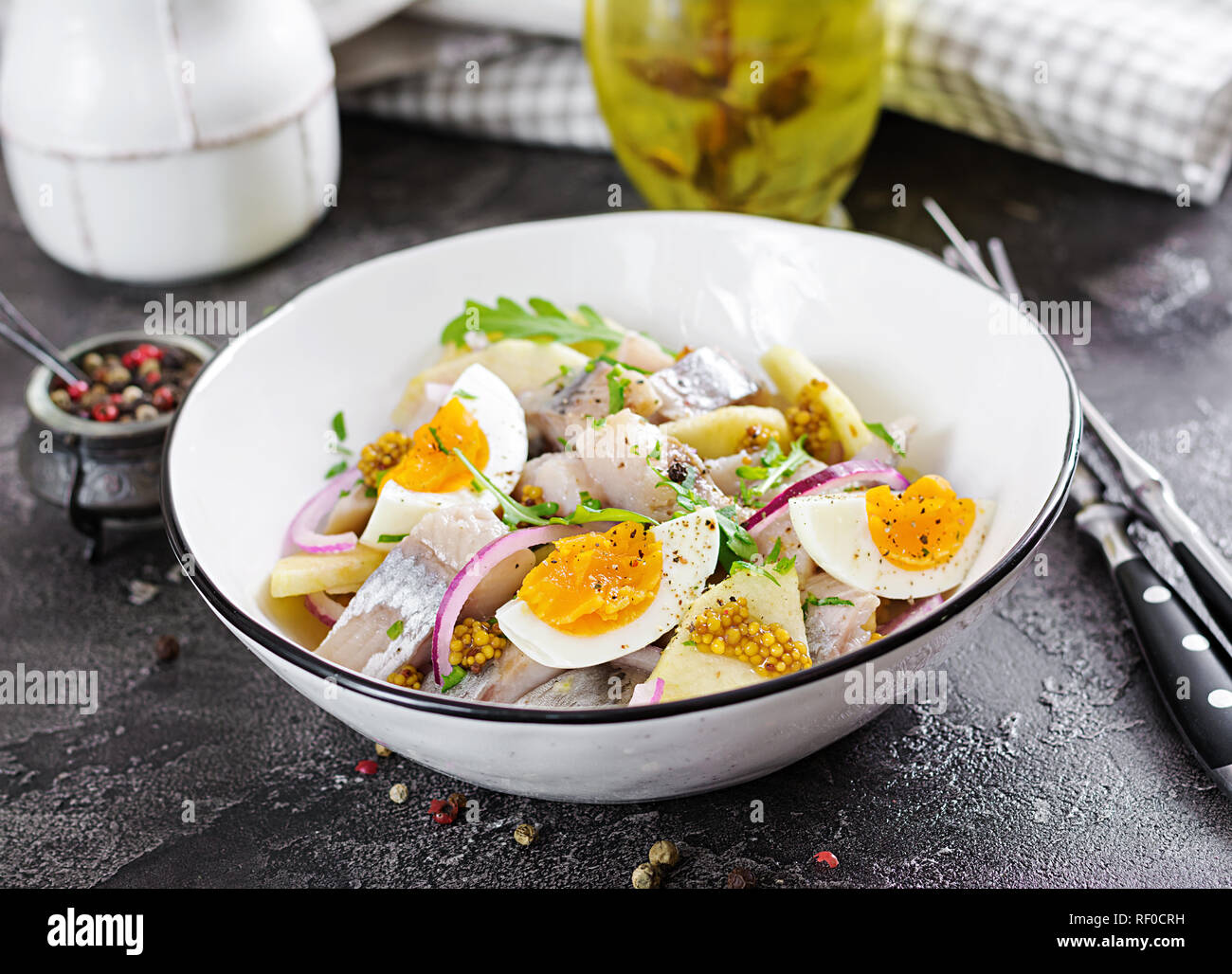 Tradizionale insalata di aringhe salate filetto, mele fresche, cipolla rossa e uova. Cibo Kosher. Cucina scandinava. Foto Stock