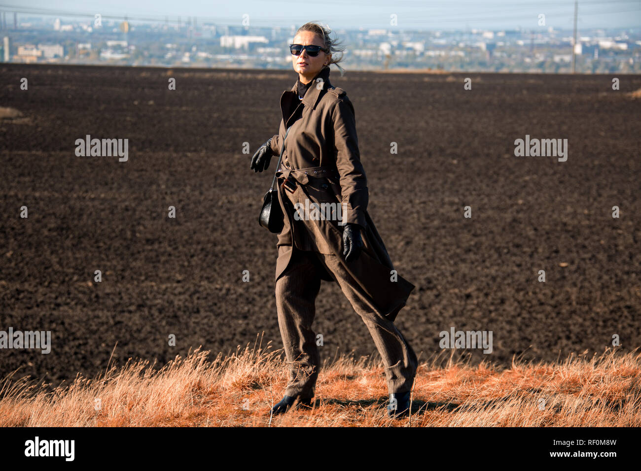 La donna in una tuta su una collina in un campo abbandonato Foto Stock