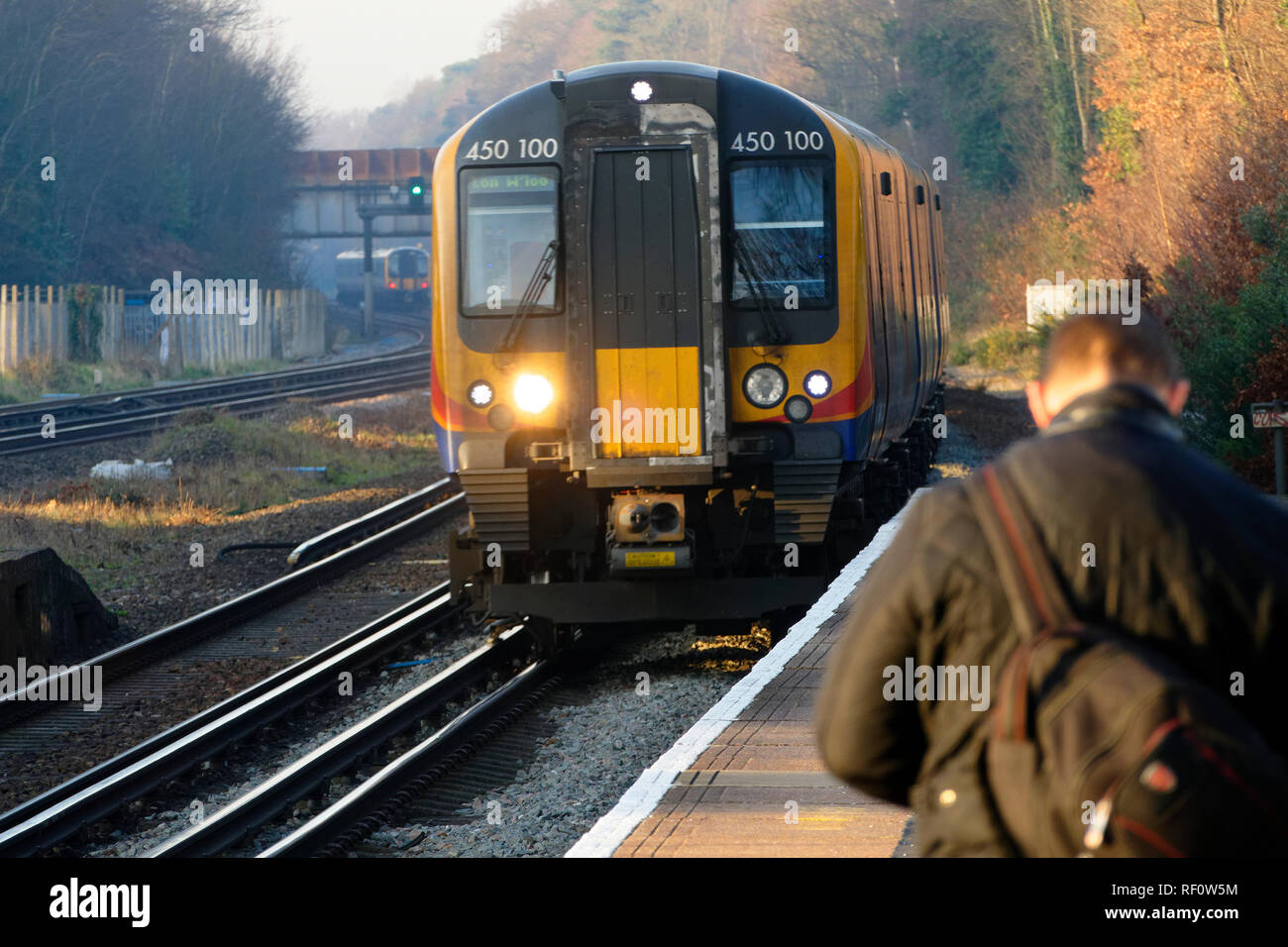 Passeggeri britannici Treno in avvicinamento piattaforma ferroviaria, Londra, Regno Unito. Foto Stock