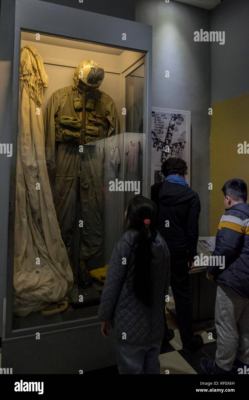 I bambini che guardano un volo Americano tuta e paracadute a Hanoi Hilton prison museum ad Hanoi, Vietnam. Foto Stock