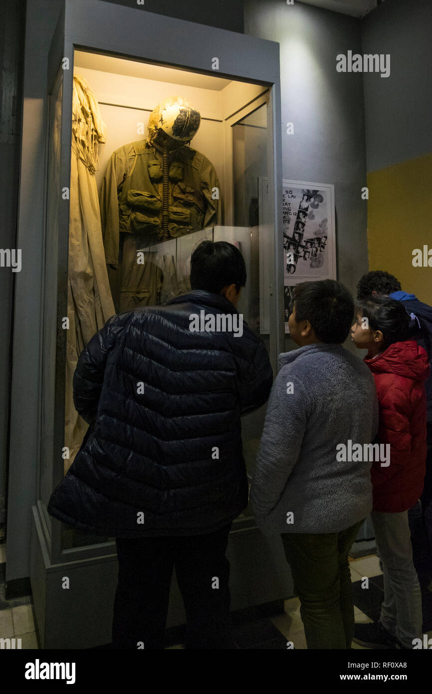 I bambini che guardano un volo Americano tuta e paracadute a Hanoi Hilton prison museum ad Hanoi, Vietnam. Foto Stock