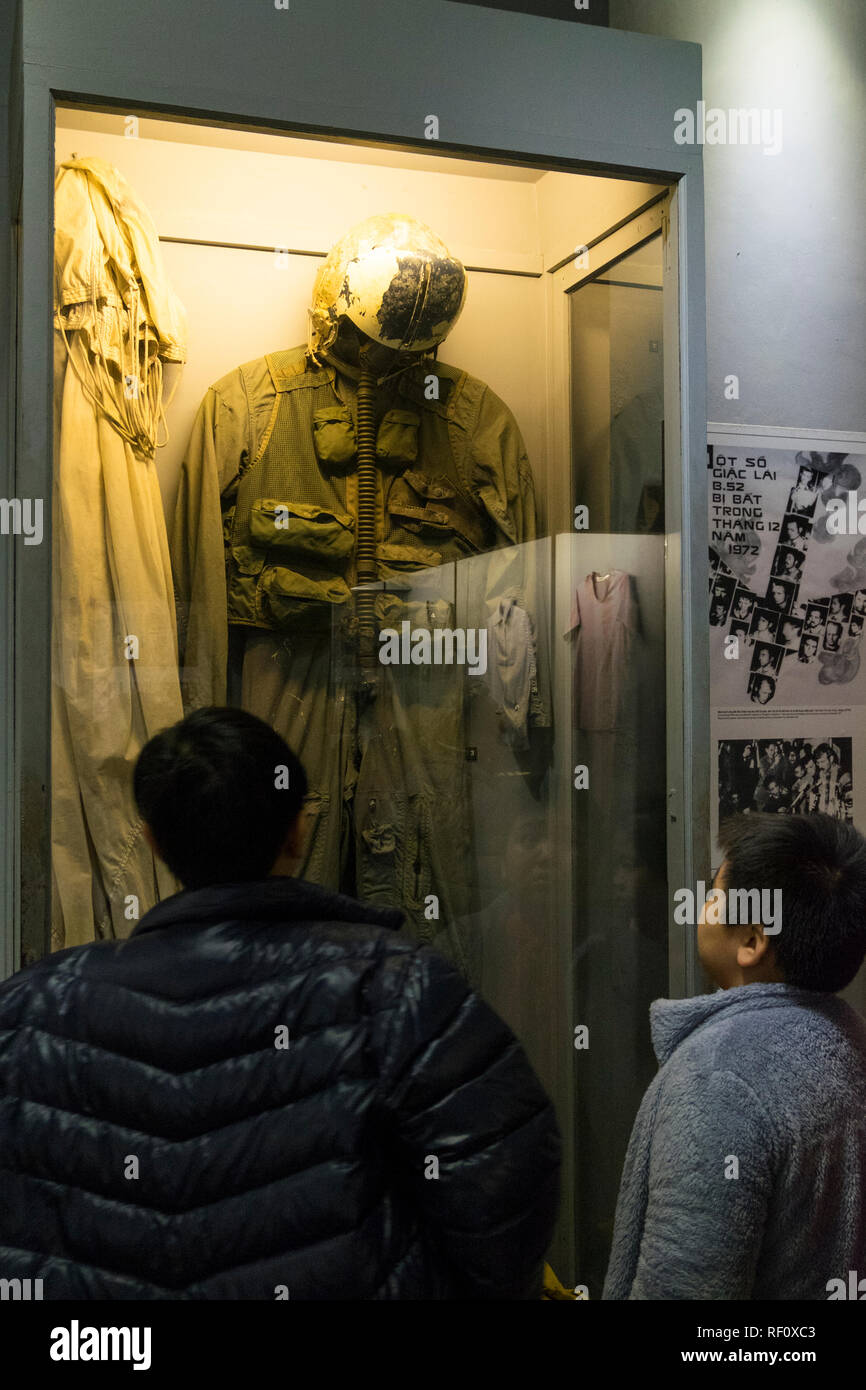 I bambini che guardano un volo Americano tuta e paracadute a Hanoi Hilton prison museum ad Hanoi, Vietnam. Foto Stock