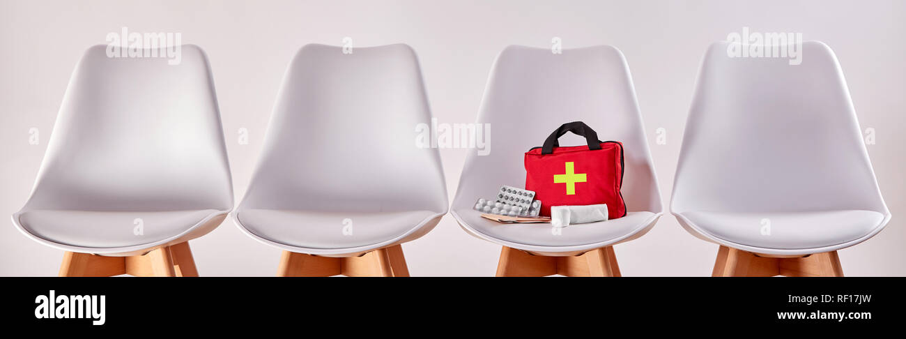 Concetto medico con sedie con kit di primo soccorso Foto Stock