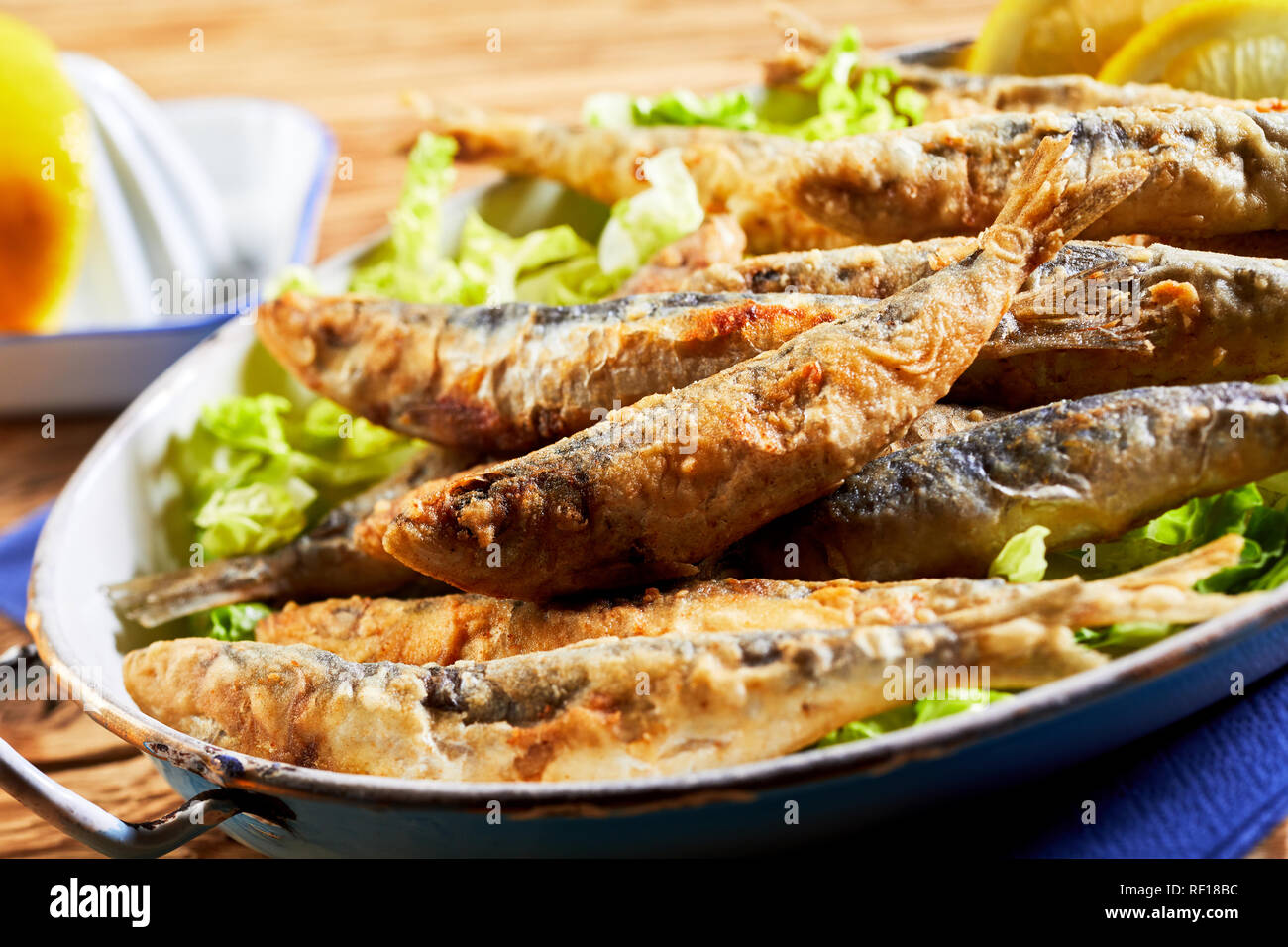 Piastra del fritto croccante di sardine, le sarde o acciughe, un tradizionale piatto mediterraneo, in una vista ravvicinata con messa a fuoco selettiva per uno di pesce Foto Stock