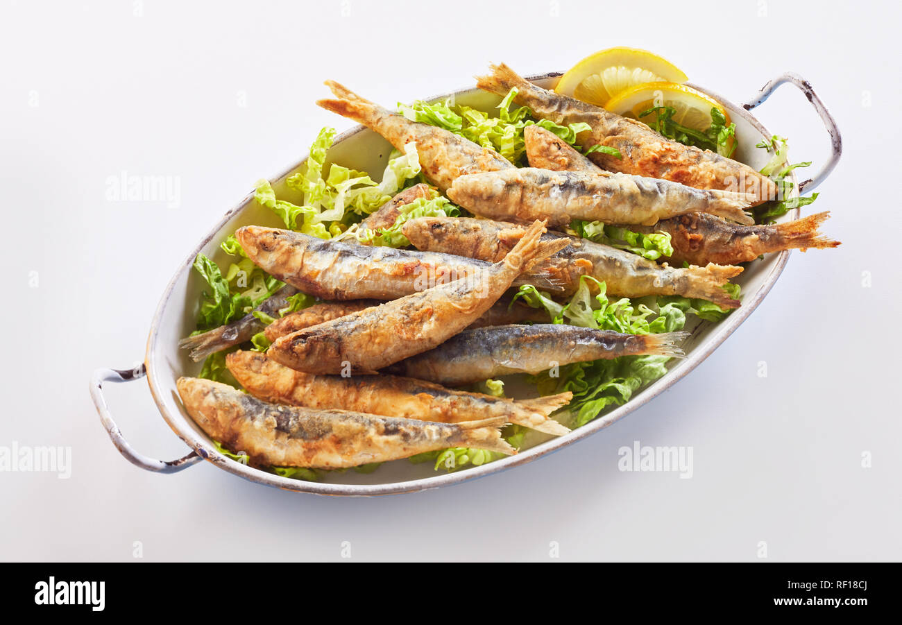 Sana greco regionale pasto a base di pesce di croccante le sardine fritte in pastella su lattuga fresca Foto Stock