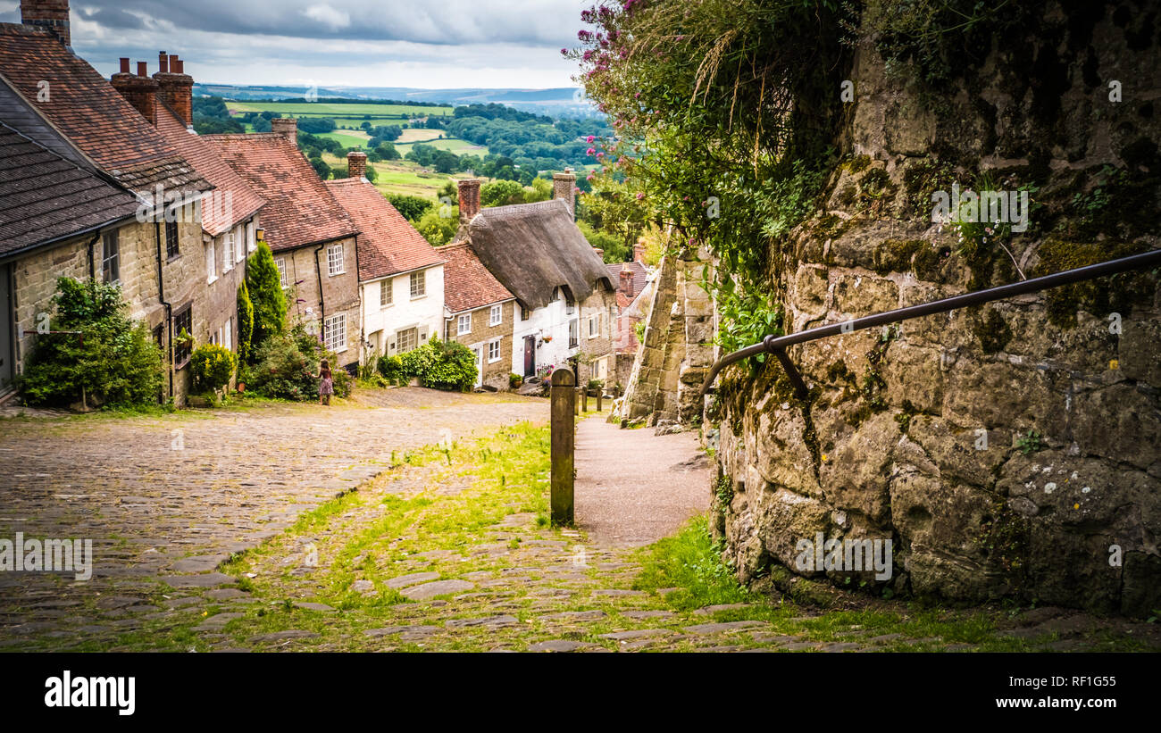 Collina d'oro in Shaftesbury è un autentico luogo nel sud del Regno Unito. Una vecchia strada di pietra su una collina con il vecchio inglese calcare case dai tetti di paglia. Foto Stock