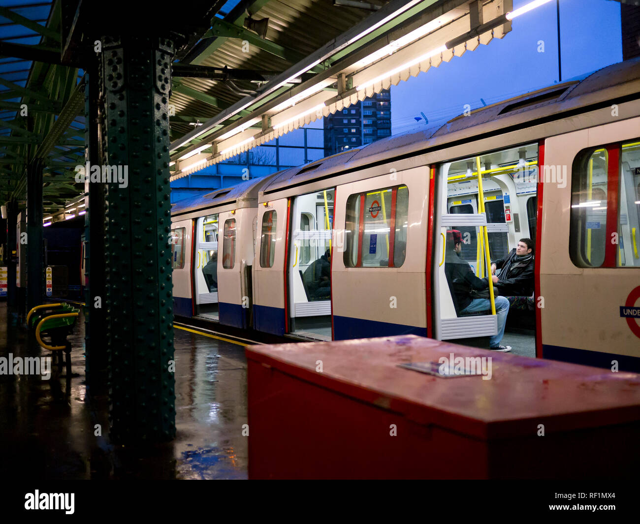 La District Line della metropolitana di Londra in attesa del treno con le sue porte aperte presso la piattaforma della stazione di Whitechapel Foto Stock