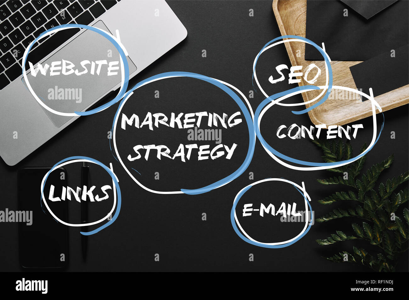 Smartphone e portatile su sfondo nero con la strategia di marketing, seo, contenuto e-mail, i collegamenti e le icone dei siti web Foto Stock