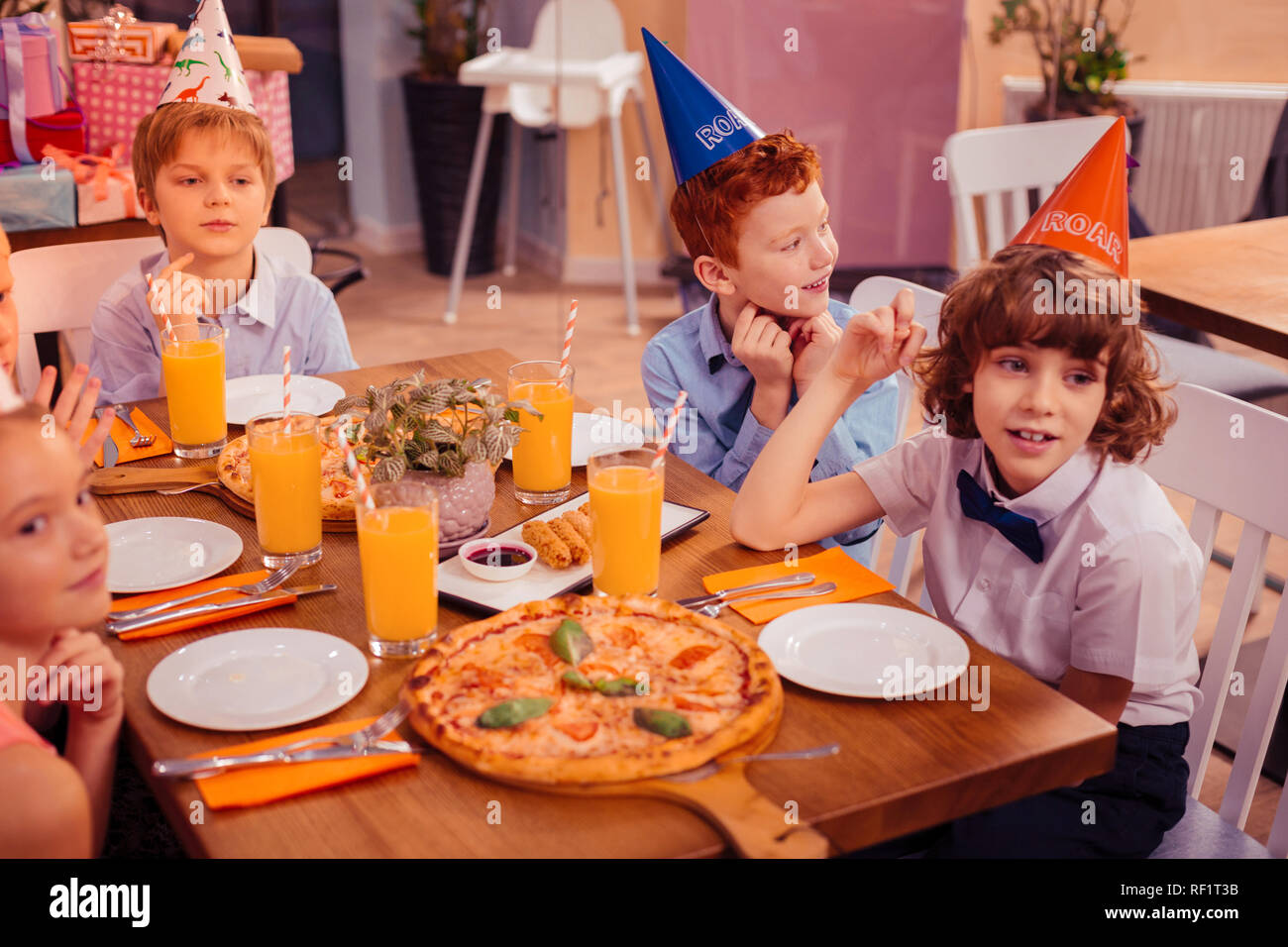 Un gruppo di bambini seduti in cafe insieme Foto Stock