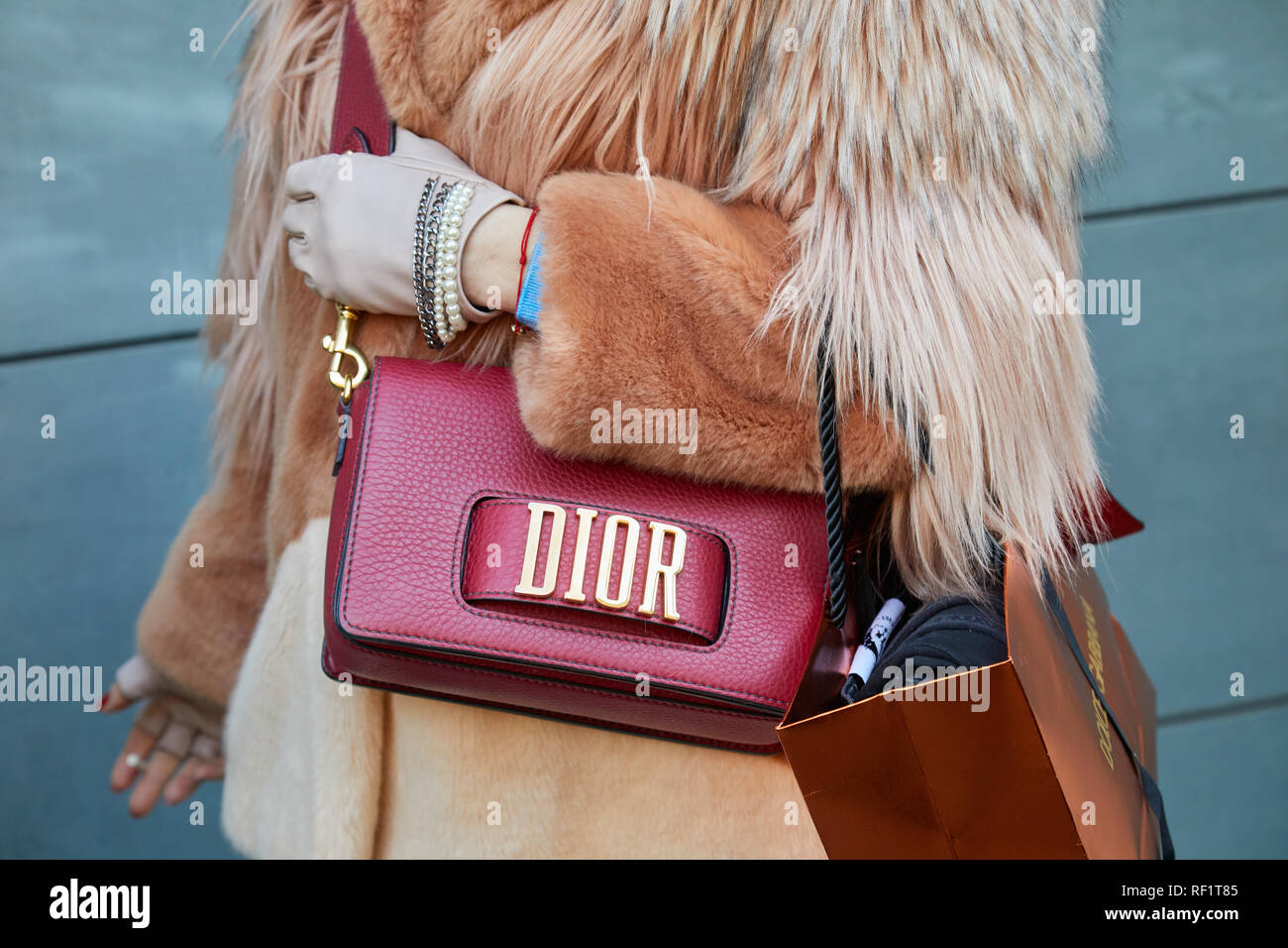 Milano Italia 13 gennaio 2019 Donna con pelle di colore rosso Dior borsa marrone e pelliccia prima di John Richmond sfilata di moda la Settimana della Moda Milanese street style Foto stock Alamy