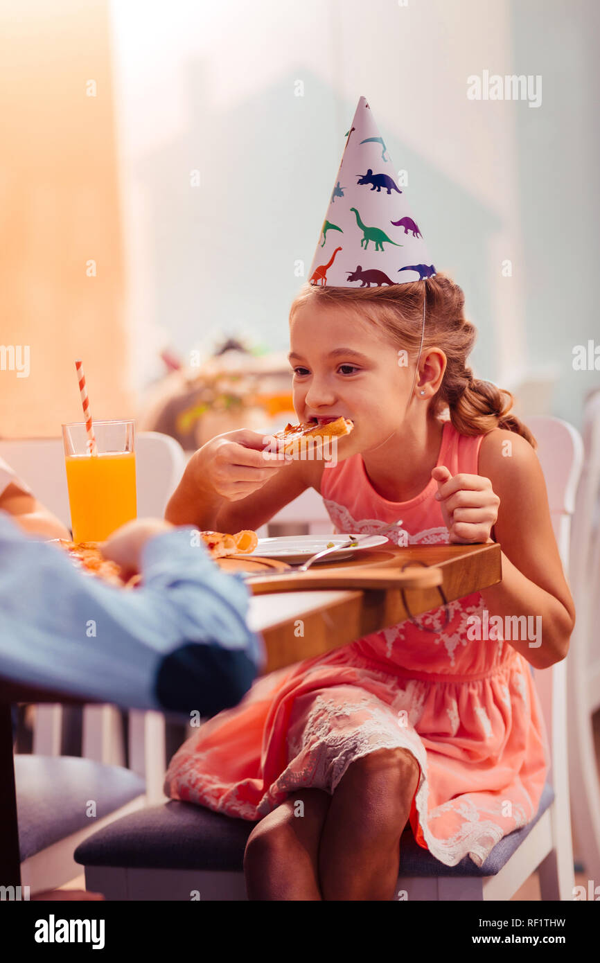 Fame ragazza bionda di mangiare la pizza con grande piacere Foto Stock