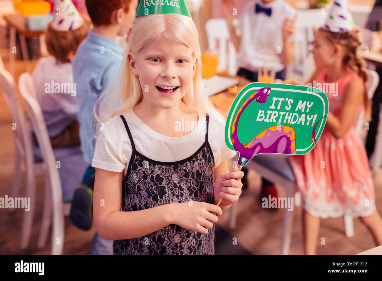 Carino longhaired compleanno ragazza sensazione di felicità durante il party Foto Stock