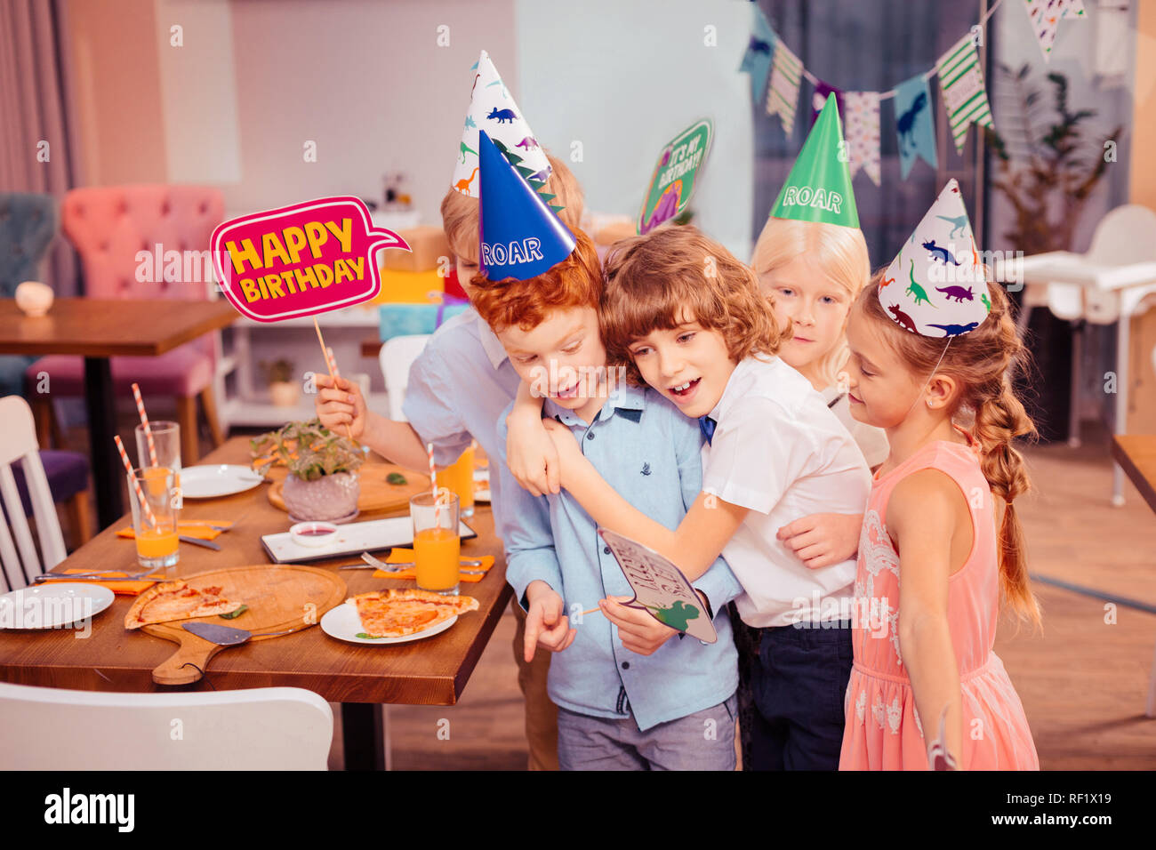 Positivo il piacere ai bambini di prendere foto con il ragazzo di compleanno Foto Stock