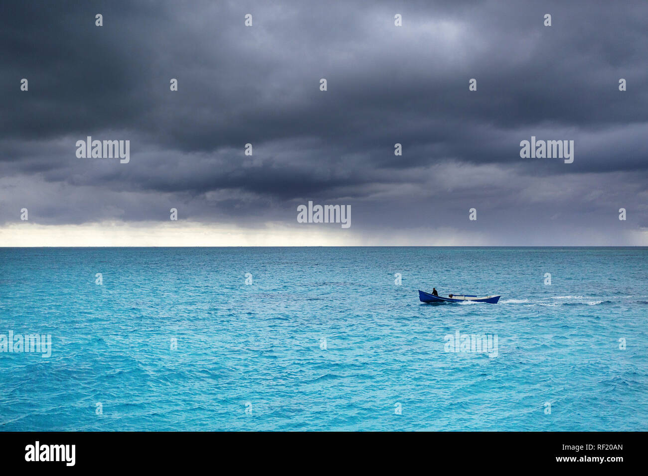 Pescatore in barca a vela durante le tempeste tropicali di acqua turchese, Iriomote, Giappone Foto Stock