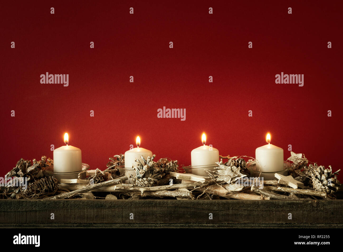 Il tempo di avvento quattro candele accese con sfondo rosso per i tuoi contenuti Foto Stock