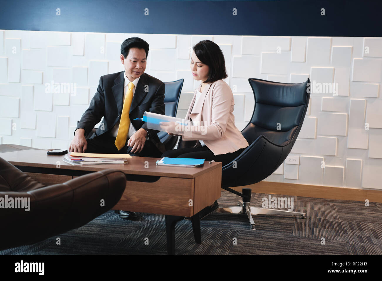 Piano di investimenti Agent mostra documenti ai clienti asiatici in banca Foto Stock