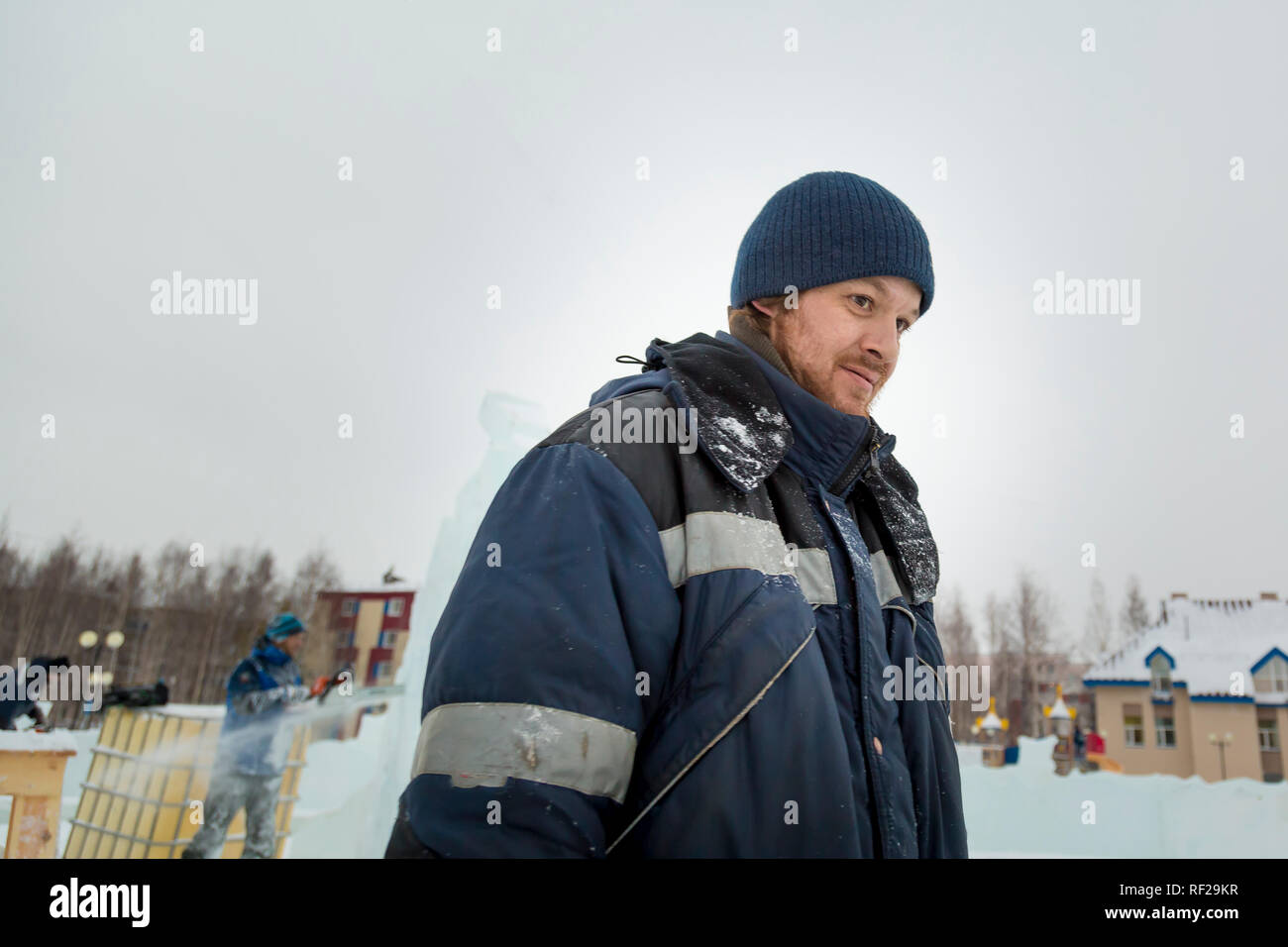 Ritratto di un lavoratore presso un sito di assemblaggio di una città di ghiaccio in inverno tute da lavoro Foto Stock