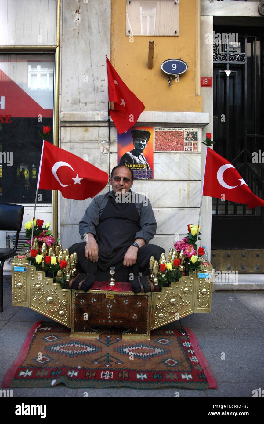 Lustrascarpe uomo con bandiere turche in Beyoglu, Istanbul, Turchia Foto Stock