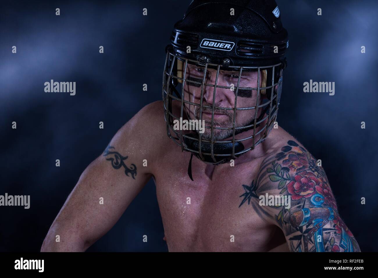 Ritratto, uomo con tatuaggio, football americano casco, vista scuro, Germania Foto Stock