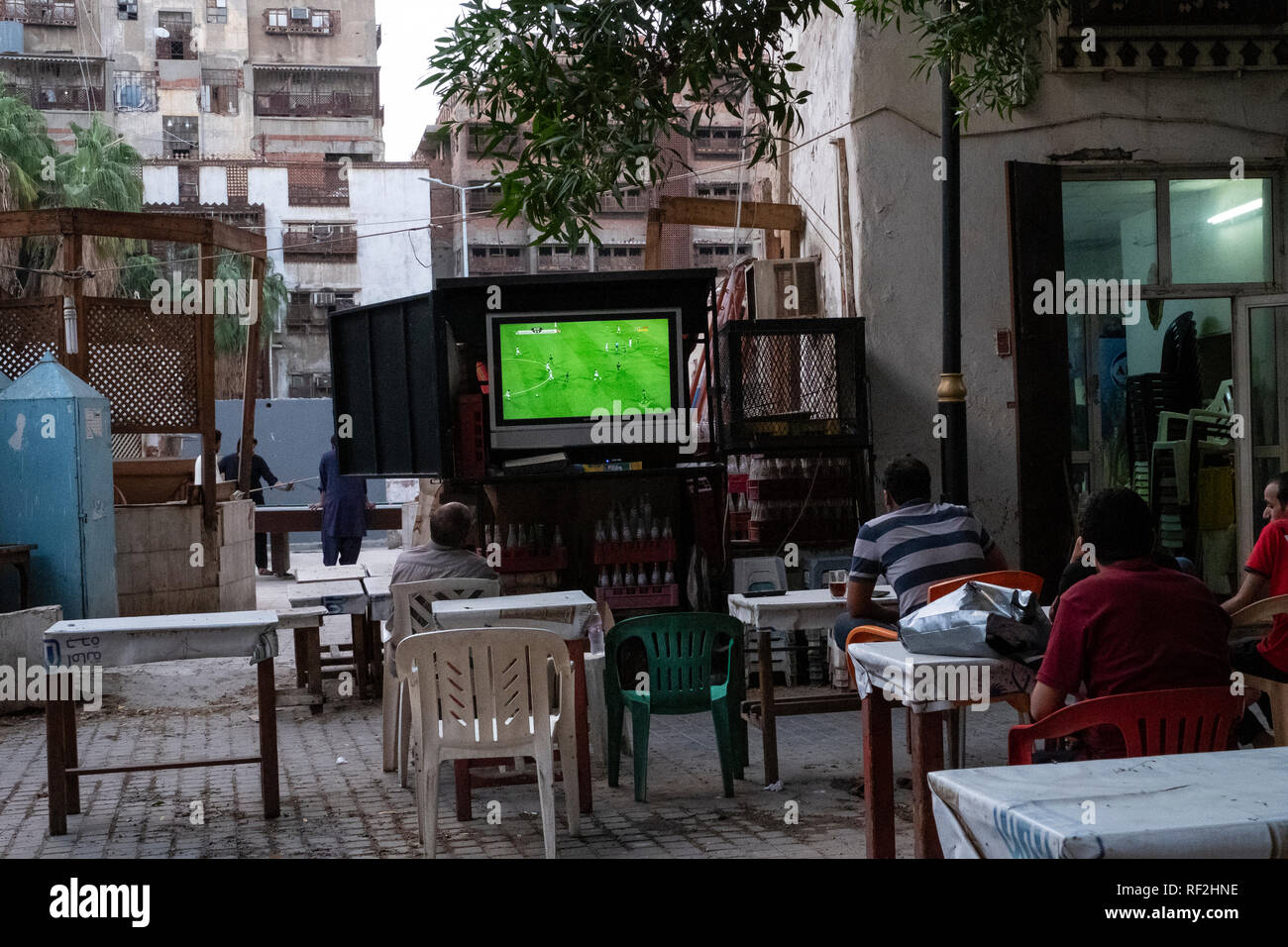 Gli uomini riuniti in un cafe' all'aperto a guardare una partita di calcio in Jeddah, Arabia Saudita Foto Stock