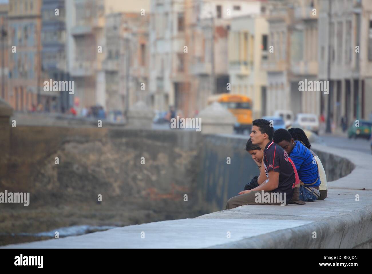 I giovani seduti su una parete, Malecón, Havana, Cuba, Caraibi Foto Stock