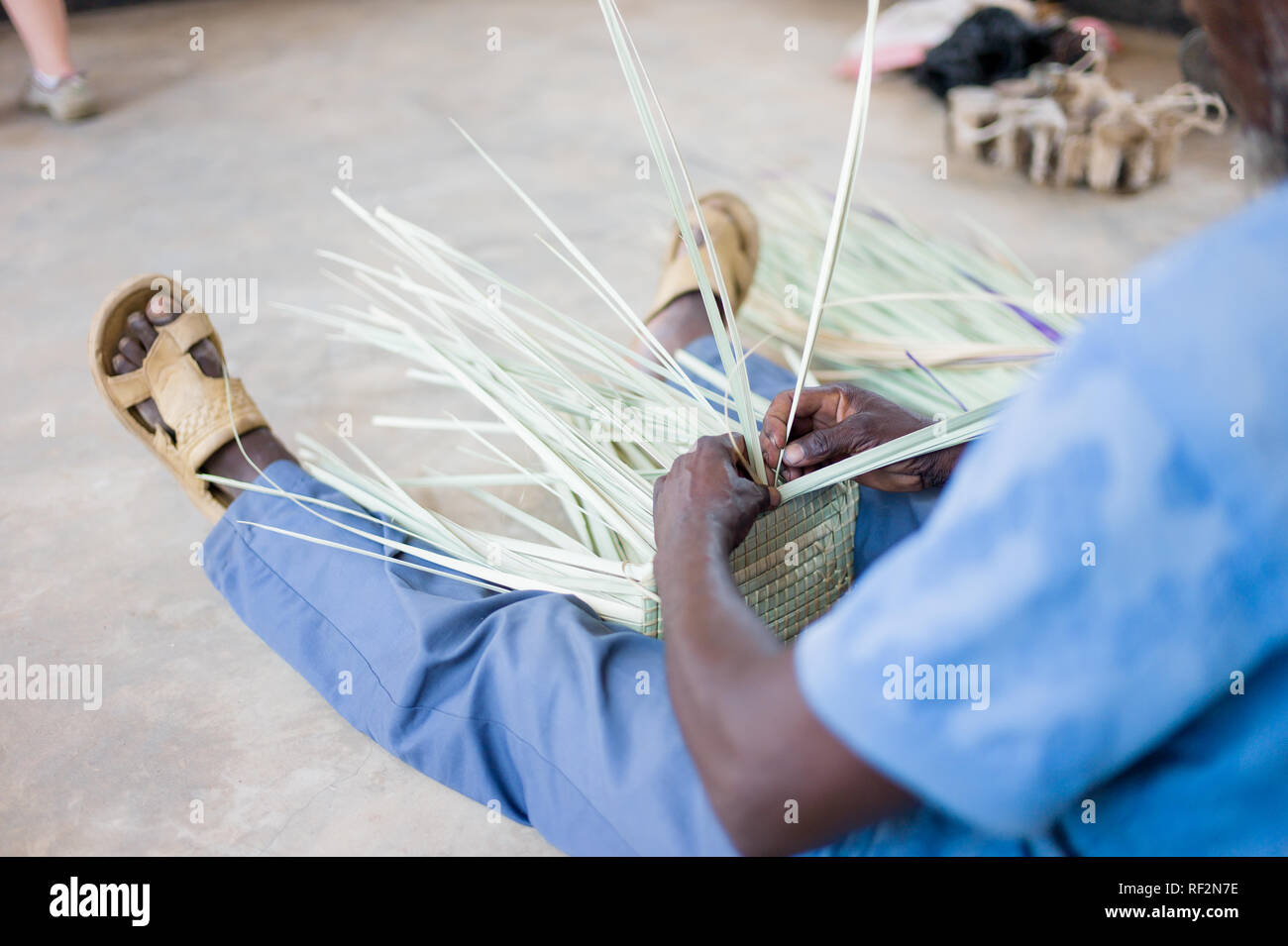 Un uomo del Malawi si intreccia cesti come parte della comunità di un vasto programma di Majete riserva faunistica in Malawi; le comunità locali souvenir artigianali da vendere Foto Stock