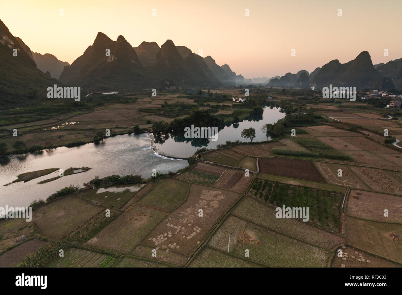 Sunset sorpassa il montagne carsiche e campi di riso lungo il fiume Pearl in Cina visto da discendente in mongolfiera ad aria calda Foto Stock