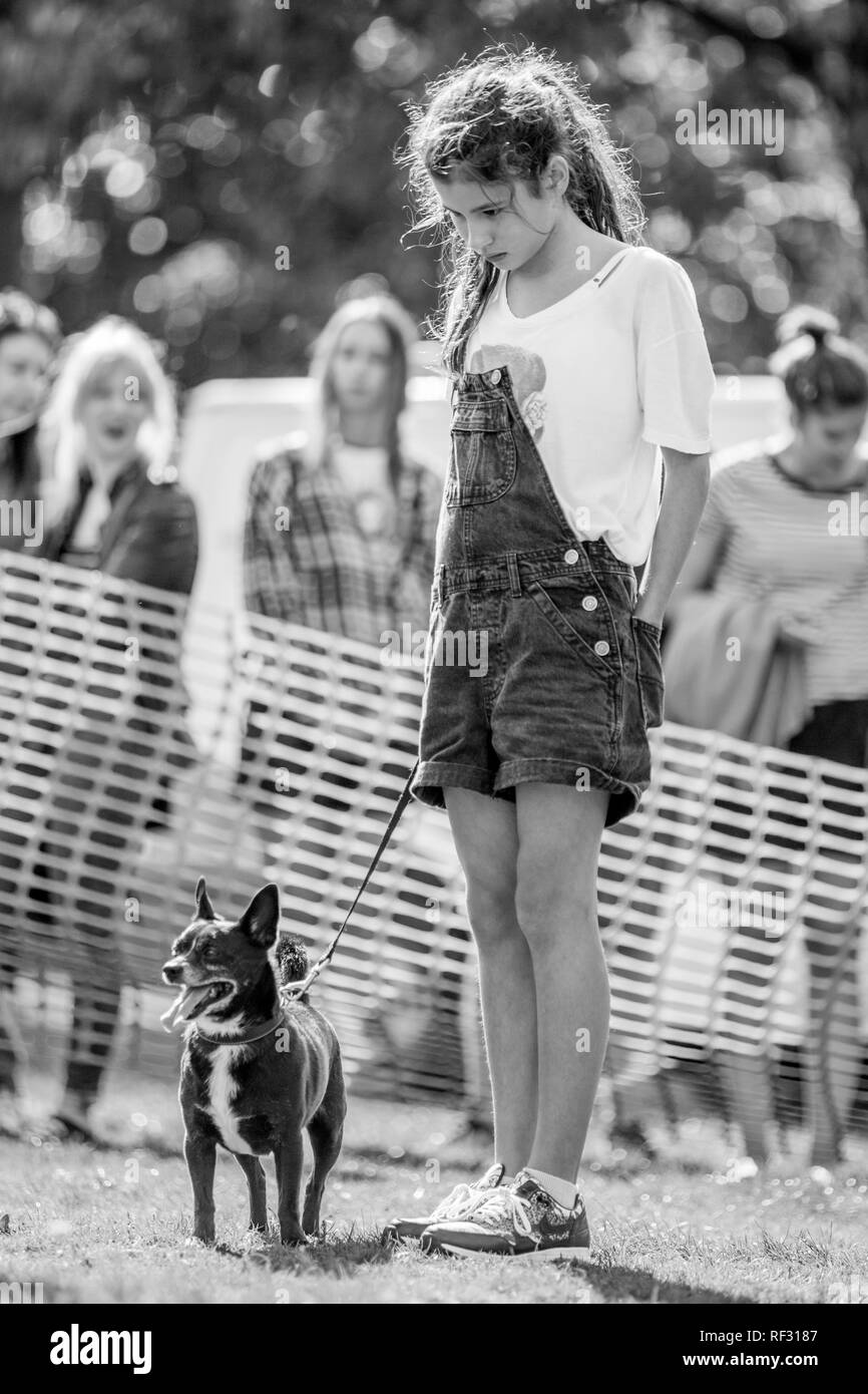 Una giovane ragazza con il suo cucciolo il parco presso un dog show. Foto Stock
