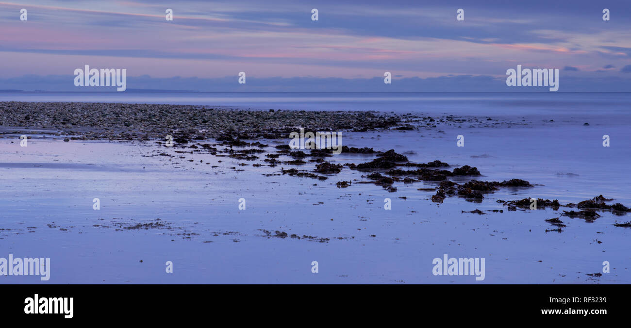 Charmouth, Dorset, Regno Unito. Il 23 gennaio 2019. Regno Unito: Meteo una fredda sera invernale presso il villaggio sul mare di Charmouth, West Dorset. I cieli guardando fuori sopra il Golden Cap e la Jurassic Coast sono colorati con wintery rosa come il sole tramonta su una fredda sera di gennaio. Credito: Celia McMahon/Alamy Live News Foto Stock