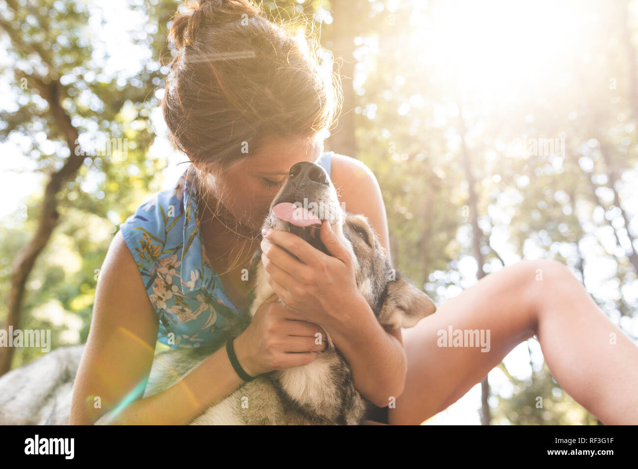 Giovane donna cuddling il Suo cane nei Boschi Foto Stock