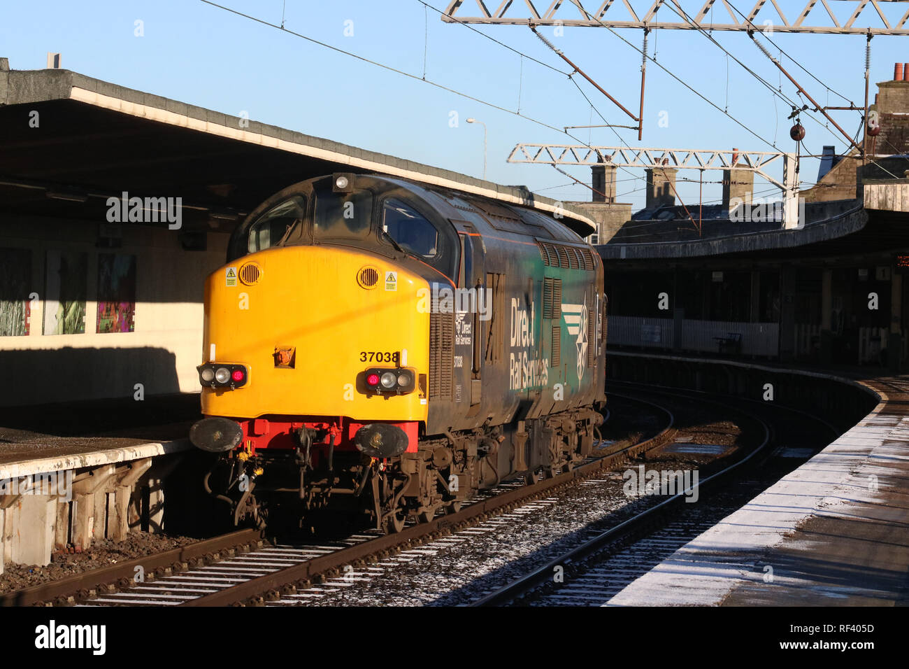 Classe 37 diesel-elettrico in loco direttamente i servizi ferroviari livrea nella luce di lavoro del motore che passa attraverso la stazione di Carnforth piattaforma 2 il 23 gennaio 2019. Foto Stock